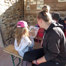 Animatrice avec enfant devant une carte de course d'orientation